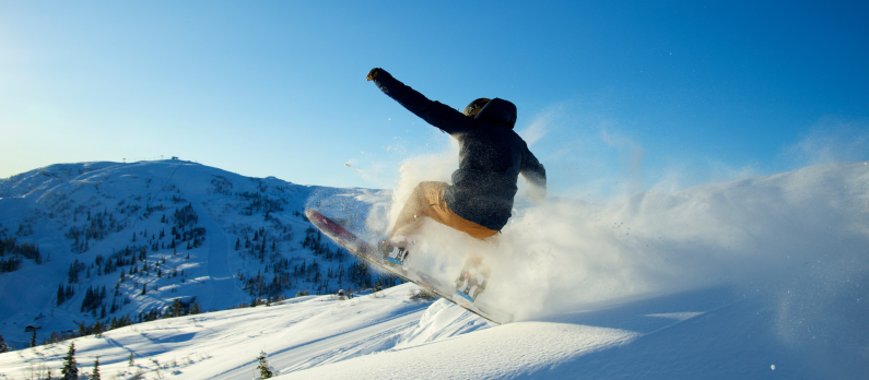 En person står på snowboard i vinterlandskap