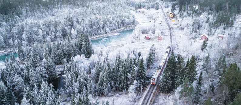 Tog på vei gjennom snødekt landskap i Hordaland