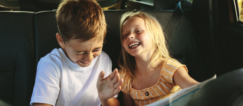 Two kids laughing in car