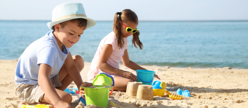 children playing with buckets and spades at the beach