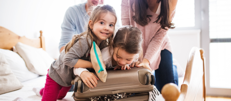 Happy family packing suitcase