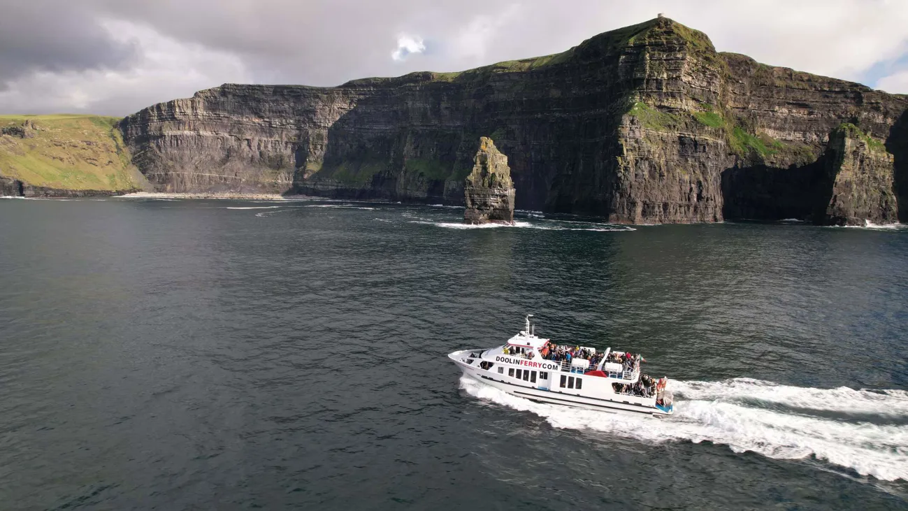 Image of boat sailing infront of the Cliffs of Moher